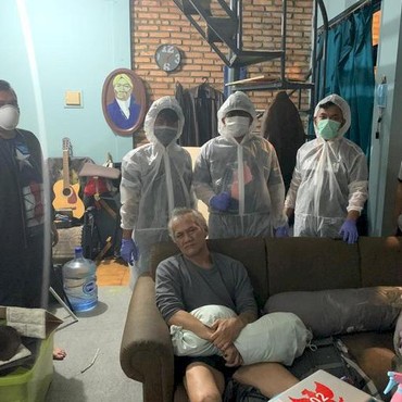 Foto Tio Pakusadewo Terduduk Lemas saat Ditangkap Polisi Berpakaian APD