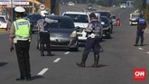 Jelang PSBB Bogor, Bekasi, Depok Petugas kepolisan dan Dinas Perhubungan memeriksa penumpang pengendara mobil yang tidak menggunakan masker maupun duduk tanpa jarak saat sosialisasi jelan peerapan Pembatasan Sosial Berskala Besar (PSBB) di pintu tol bekasi barat, Bekasi, Jawa Barat, Selasa, 14 April 2020. PSBB Bekasi akan diberlakukan besok bersamaan kota Bogor, Kabupaten Bogor dan Kabupaten Bekasi. CNNIndonesia/Safir Makki