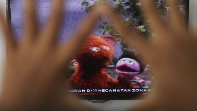 Seorang anak menonton televisi siaran perdana 'Belajar dari Rumah' tingkat PAUD yang diselenggarakan Kementerian Pendidikan dan Kebudayaan (Kemendikbud) di Kota Kediri, Jawa Timur, Senin (13/4/2020). Kemendikbud menyiapkan 720 episode untuk penayangan Belajar dari Rumah selama 90 hari di TVRI bagi pelajar tingkat PAUD hingga SMA. ANTARA FOTO/Prasetia Fauzani/hp.