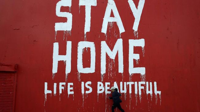 A jogger runs by a mural which reads 