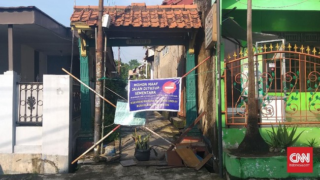 Sejumlah warga Depok menerapkan isolasi mandiri di pintu masuk perumahan mereka pada hari pertama PSBB Kota Depok, Rabu (15/4). Area pertokoan juga terpantau sepi, sebagian besar toko tutup.