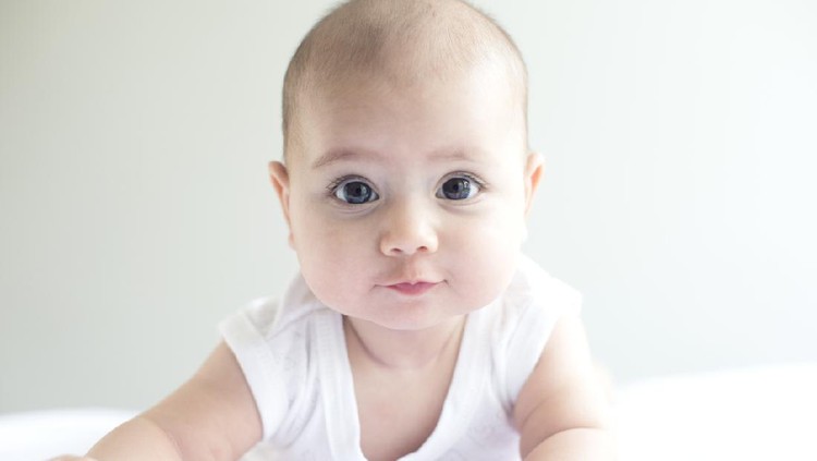 Baby Cute little baby boy with little rabbit in bed after bath, baby after shower, cute child smiling at camera, bunny hext to him