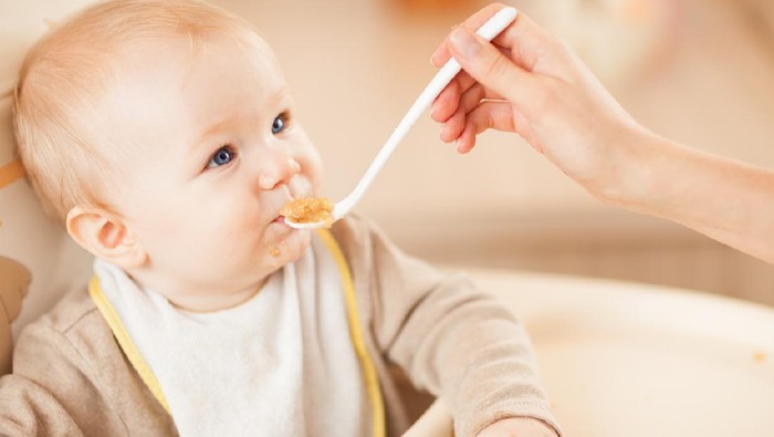 Mother and baby boy smiling wach other during feeding