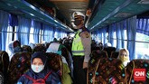 HARI PERTAMA PSBB KOTA BEKASI Polisi memeriksa bus karyawan yang tidak tertib aturan PSBB di pintu tol keluar Bekasi, Jawa Barat, Rabu, 15 April 2020. Pembatasan Sosial Berskala Besar (PSBB) dimulai hari ini di Kota Bekasi hingga 28 April 2020. CNNIndonesia/Safir Makki