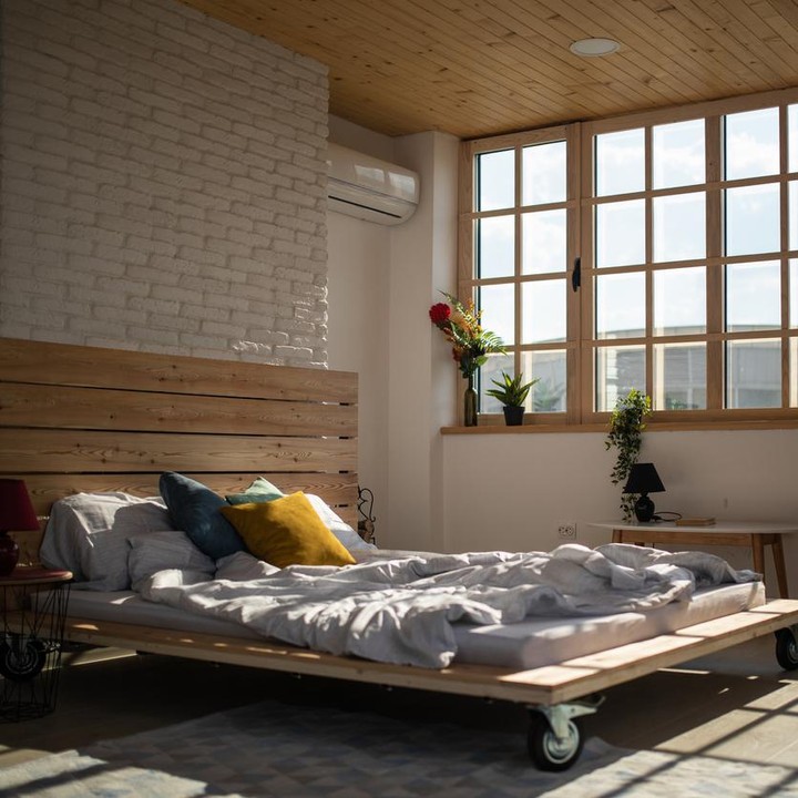 <p>Kamar serba kayu dengan kaca yang lebar seperti ini membuat kamar terasa hangat dan nyaman. Selain itu, tempat tidur kamar ini juga unik dengan 4 roda di bawahnya. (Foto: iStock)</p>