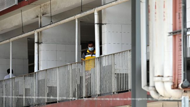 Nasib Imigran Asing di Tengah Corona Singapura A foreign worker, wearing face mask as a preventive measure against the spread of the COVID-19 novel coronavirus, looks out from a window of the workers' dormitory in Singapore on April 9, 2020. - Migrant workers in Singapore are living in fear following a surge of coronavirus infections in their dormitories where they say cramped and filthy conditions make social distancing impossible. (Photo by Roslan RAHMAN / AFP) / TO GO WITH Health-virus-Singapore-migration, FOCUS by Catherine Lai and Sam Reeves