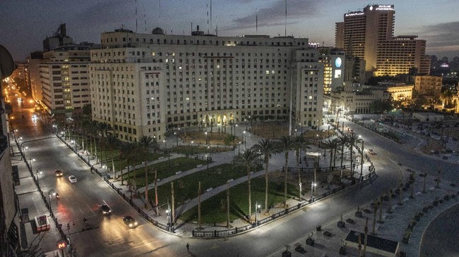 In this March 29, 2020 photo, Egyptian security forces cordon off roads during curfew hours due to the coronavirus outbreak, in Cairo, Egypt. Since early March, the government has shuttered schools, mosques, churches and archaeological sites, and ordered restaurants, coffee shops, malls and gyms to close to encourage people to stay home and slow the virus' spread. A curfew is set in place from 8 p.m. to 6 a.m. (AP Photo/Nariman El-Mofty)