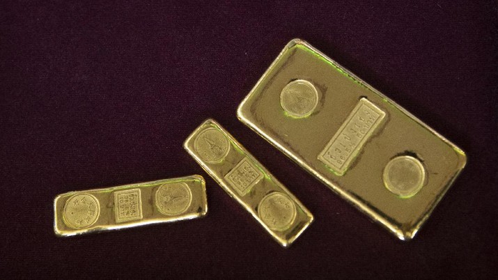 A customer puts gold bar on basket for sell to the gold shop in Bangkok, Thailand, Thursday, April 16, 2020. With gold prices rising to a seven-year high, many Thais have been flocking to gold shops to trade in their necklaces, bracelets, rings and gold bars for cash, eager to earn profits during an economic downturn.(AP Photo/Sakchai Lalit)