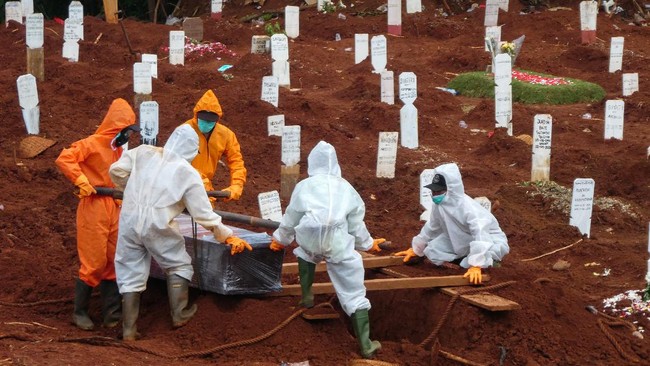 Workers move a coffin of a victim of the COVID-19 coronavirus to a burial site at a cemetery in Jakarta on April 15, 2020. (Photo by Bay ISMOYO / AFP)