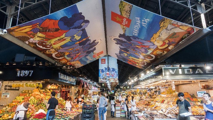 Barcelona, Spain - June 2, 2017: Tourists visiting the La Boqueria Market, the most famous market in Barcelona. It is located in the heart of Barcelona on La Rambla street. The Boqueria Market offering wide selection of fruits, vegetables, spices, fish, meat etc.