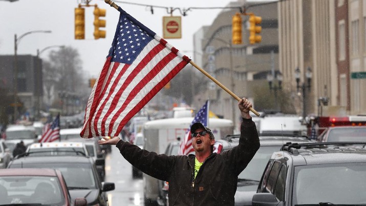 A Trump Unity sign on a trailer is shown parked at a protest in front of the Michigan State Capitol in Lansing, Mich., Wednesday, April 15, 2020. Flag-waving, honking protesters drove past the Michigan Capitol on Wednesday to show their displeasure with Gov. Gretchen Whitmer's orders to keep people at home and businesses locked during the new coronavirus COVID-19 outbreak. (AP Photo/Paul Sancya)