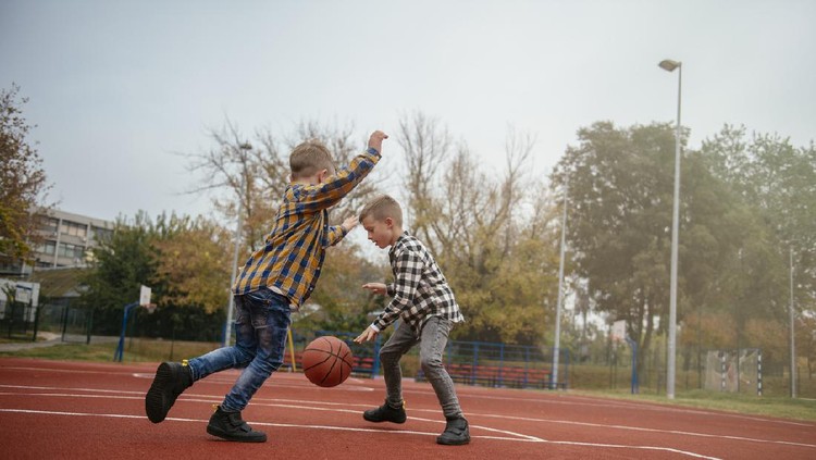 Family having fun time at basketball field. Shadow DOF. Developed from RAW; retouched with special care and attention; Small amount of grain added for best final impression. 16 bit Adobe RGB color profile.