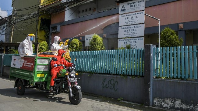 Petugas Palang Merah Indonesia (PMI) menyemprotkan cairan disinfektan di asrama Sekolah Tinggi Teknologi Bethel, Jakarta, Jumat (17/4/2020). Penyemprotan disinfektan pada kawasan tersebut sebagai upaya mencegah dan memutus rantai penyebaran COVID-19 setelah adanya 34 mahasiswa penghuni asrama itu yang positif virus corona. ANTARA FOTO/Galih Pradipta/pras.