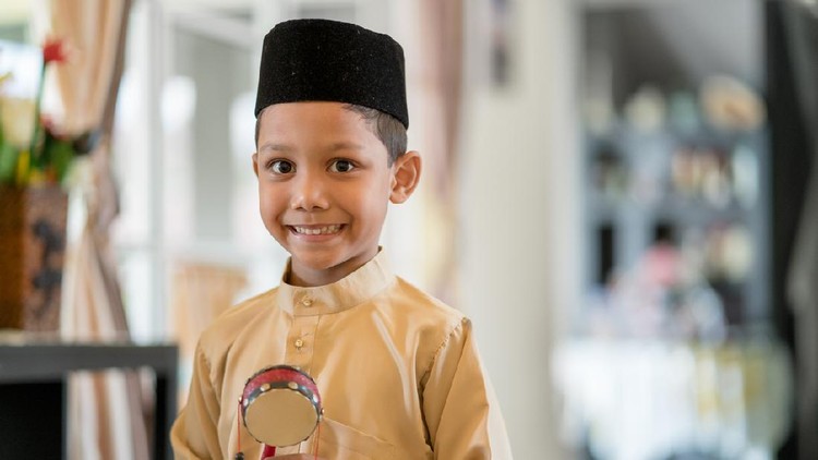 Anak Puasa Young boy wearing traditional clothes looking excited in anticipation of the Islamic celebration of Hari Raya Aidilfitri (Eid al-Fitr). Kuala Lumpur, Malaysia. May 2018