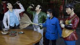 Nyalang Edisi 18 April 2020 A cleaner wearing a mask to help stop the spread the coronavirus sweeps replicas of food and statues depicting normal life along a retail street in Wuhan, central China's Hubei province, Thursday, April 9, 2020. Released from their apartments after a 2 1/2-month quarantine, residents of the city where the coronavirus pandemic began are cautiously returning to shopping and strolling in the street but say they still go out little and keep children home while they wait for schools to reopen. (AP Photo/Ng Han Guan)