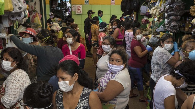 Women, wearing protective face masks, wait to buy food at a popular market in Lima, Peru, Saturday, April 4, 2020. Due to the health emergency from the spread of the new coronavirus, the government is restricting people's movement by gender, with Saturday designated to women, who can leave home to buy basic necessities. (AP Photo/Rodrigo Abd)