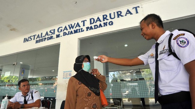 Petugas keamanan memeriksa suhu tubuh pengunjung RSUP Dr.M.Djamil, Padang, Sumatera Barat, Kamis (12/3/2020). Rumah sakit itu menerapkan sistem 