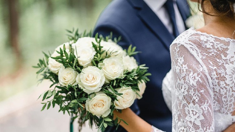 1147779582 Happy bride and groom on their wedding hugging