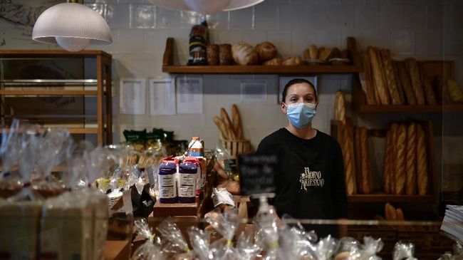 In this Tuesday, April 14, 2020 photo, Rocio Satrustegui poses for a photograph at her bakery in Pamplona, northern Spain. As Spain hunkers down after five weeks of home confinement, there are the brave few who keep the country going during a coronavirus outbreak that has killed over 20,000 of their fellow citizens. These laborers_ butchers, taxi drivers, pharmacists_ in the northern city of Pamplona as well as the rest of Spain's cities and towns are unified by their courage and one piece of equipment: the face mask. (AP Photo/Alvaro Barrientos)