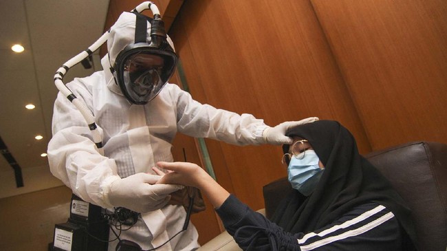 Petugas dari Tim Ahli dan Peneliti Universitas Indonesia (UI) menggunakan alat pelindung wajah berteknologi Respirator Pemurni Udara Bertenaga Baterai (RPUBB) di Gedung PAUI, Depok, Jawa Barat, Senin (20/4/2020). Tim Ahli dan Peneliti UI mengembangkan prototipe APD dalam bentuk pelindung wajah untuk tenaga medis dengan teknologi RPUBB dengan harapan mampu melindungi mereka saat bertugas merawat pasien COVID-19. ANTARA FOTO/Asprilla Dwi Adha/wsj.