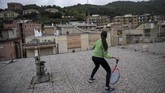 Bermain Tenis di Atap Rumah di Tengah Lockdown Covid-19 Vittoria Oliveri (front) plays tennis with Carola in background on rooftops of their house in Finale Ligure, Liguria Region, northwestern Italy on April 19, 2020, during the country's lockdown aimed at stopping the spread of the COVID-19 (new coronavirus) pandemic. - Everyday Carola, 11, and Vittoria, 13, play tennis from a rooftop to another rooftop of their homes to practice during the Covid 19 lockdown. (Photo by MARCO BERTORELLO / AFP)