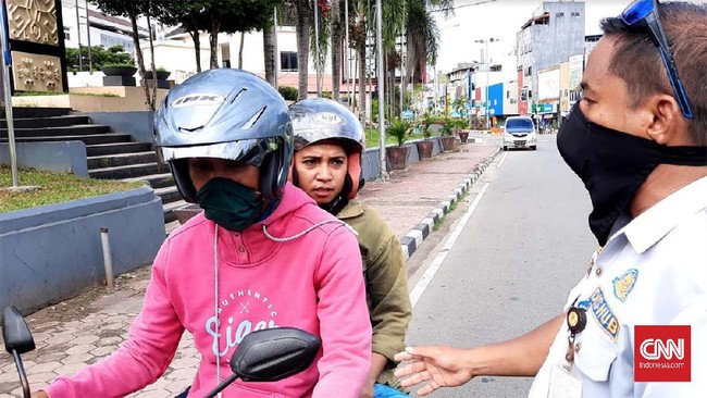 Petugas Dishub dan TNI melakukan razia kendaraan bermotor yang tak menggunakan masker di hari pertama Pemberlakukan Sosial Berskala Regional (PSBR) di Ambon, Maluku, Senin (20/4).