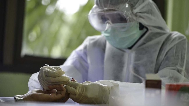 An Indonesian medical worker wearing protective gear is seen during mass testing for the COVID-19 coronavirus at a community health centre in Banda Aceh on April 20, 2020. (Photo by CHAIDEER MAHYUDDIN / AFP)