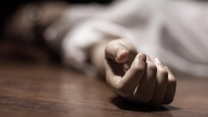 The dead woman's body. Focus on hand