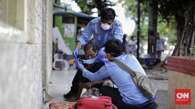 Petugas medis dari Ambulans Gawat Darurat Dinkes DKI Jakarta melakukan evakuasi seorang tunawisma di kawasan Pasar Baru. Jakarta, Selasa, 21 April 2020.