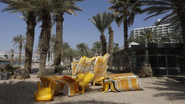 Piles of chairs are pictured at an empty Red Sea beach in the southern Israeli resort city of Eilat on April 17, 2020 amid the coronavirus COVID-19 pandemic. - Due to the novel coronavirus pandemic some 80 percent of Eilat residents lost their jobs as the city depends mostly on tourism activity which was shut down completely. (Photo by MENAHEM KAHANA / AFP)