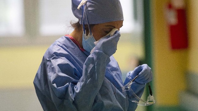 Nurse Pasqualina Conte wipes aways tears as she cries after knowing that one of her patients has a worse chance of surviving in the emergency COVID-19 ward at the San Carlo Hospital in Milan, Italy at 4.04pm at Thursday, April 16, 2020. (AP Photo/Antonio Calanni)