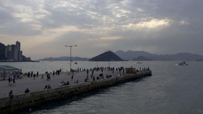 In this picture taken on April 13, 2020, people visit a public cargo loading area dubbed 'Instagram Pier' in Hong Kong. - Starting on March 29 the city's government banned public gatherings of more than four people in an effort to curb the spread of the COVID-19 coronavirus. (Photo by Daniel SUEN / AFP)