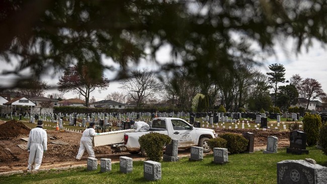 Rabbi Shmuel Plafker, left, watches as a casket is brought for burial at Mount Richmond Cemetery in the Staten Island borough of New York, Wednesday April 8, 2020. Plafker looks at the trees in bloom and the grass sprouting and finds spring's signs of rebirth so paradoxical given the death that surrounds him. He thinks of the centuries-old words he recites on the High Holy Days, that seem to carry so much more weight now. 