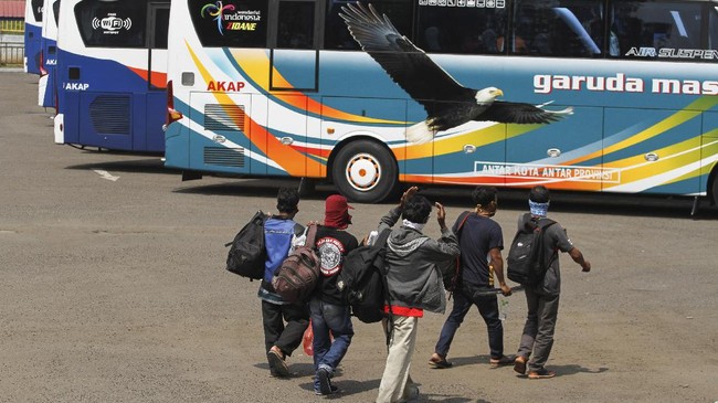 Sejumlah calon penumpang bersiap naik bus di area Terminal Jatijajar, Depok, Jawa Barat, Kamis (23/4/2020). Pemerintah memutuskan kebijakan larangan mudik Lebaran 2020 bagi masyarakat mulai berlaku Jumat (24/4) guna memutus mata rantai penyebaran COVID-19. ANTARA FOTO/Asprilla Dwi Adha/aww.