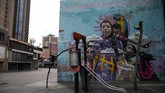 Hilangnya Wajah Ceria Taman Bermain di Dunia A playground sits deserted backdropped by a mural featuring children with a message that reads in Spanish: