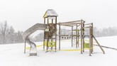 Hilangnya Wajah Ceria Taman Bermain di Dunia A playground covered in snow is closed at Normafa during during the coronavirus in Budapest, Hungary, March 23, 2020. (Marton Monus/MTI via AP)