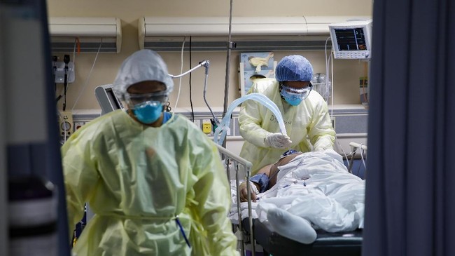 CORRECTS TO RESPIRATORY SPECIALIST FROM A NURSE - A respiratory specialist operates a ventilator for a patient with COVID-19 who went into cardiac arrest and was revived by staff, Monday, April 20, 2020, at St. Joseph's Hospital in Yonkers, N.Y. (AP Photo/John Minchillo)