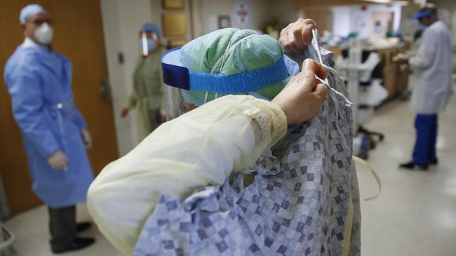 A nurse unties her gown after tending to a COVID-19 patient in the Intensive Care Unit, Monday, April 20, 2020, at St. Joseph's Hospital in Yonkers, N.Y. (AP Photo/John Minchillo)