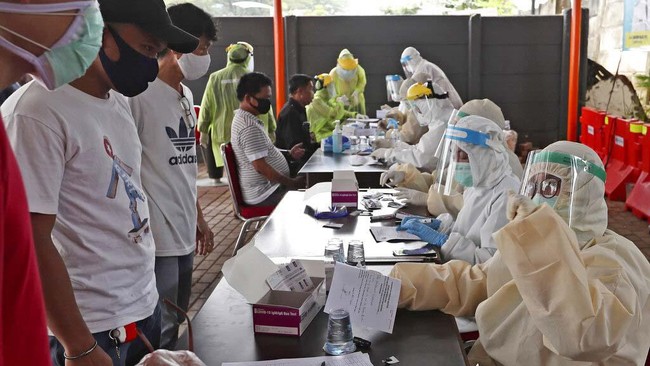 Indonesians talk to a health worker as they wait for their turn to have their blood samples taken at a coronavirus rapid test site in Tangerang, Indonesia, Tuesday, April 21, 2020. Indonesian President Joko Widodo has banned people in the world's most populous Muslim-majority nation from returning to their hometowns to celebrate Eid al-Fitr holiday that marks the end of the holy fasting month of Ramadan, amid warnings from health experts that the country could face an explosion of coronavirus cases unless the government takes stricter measures. (AP Photo/Tatan Syuflana)