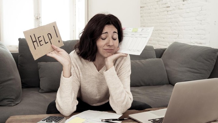Portrait of worried young woman feeling stressed and desperate asking for help in paying bills, debts, tax expenses and accounting home finances with laptop. In online banking and financial problems.