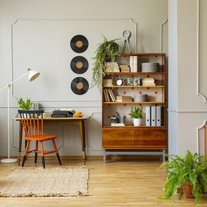 <p>Lemari kayu terbuka dan hiasan dinding dari piringan hitam, bisa menambah kesan retro di dalam rumah minimalis. (Foto: iStock)</p>