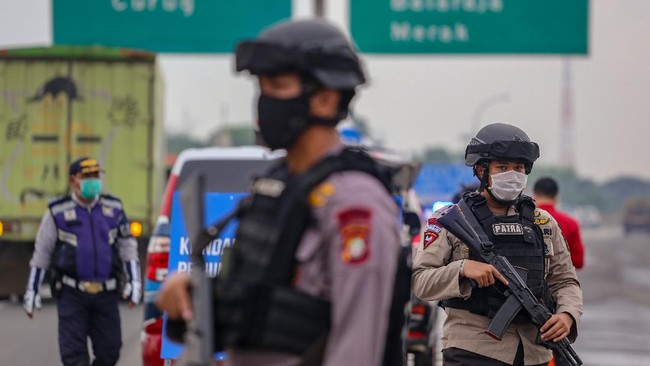 Petugas kepolisian berjaga saat dilakukan penyekatan kendaraan di pintu keluar Tol Bitung, Kabupaten Tangerang, Banten, Jumat (24/4/2020). Penyekatan itu dilakukan menyusul adanya larangan mudik bagi seluruh kalangan yang sudah ditetapkan mulai hari ini guna mencegah penyebaran COVID-19. ANTARA FOTO/Fauzan/wsj.