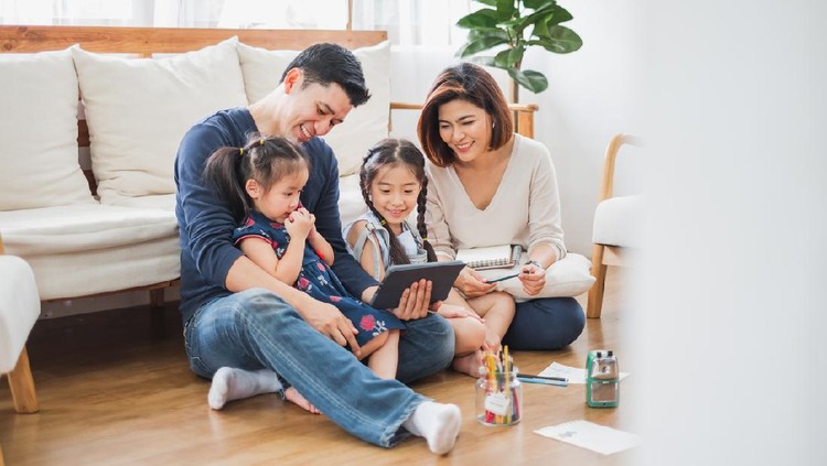 Happy Asian family using tablet, laptop for playing game watching movies, relaxing at home for lifestyle concept