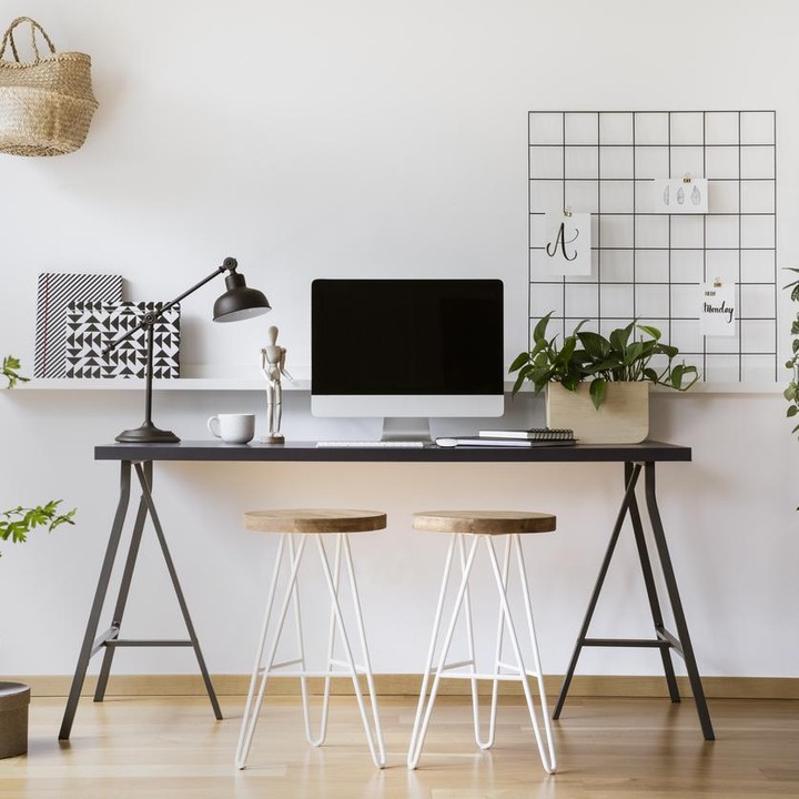 Ruangan berdinding putih tidak selalu berkesan monoton. Dengan tambahan meja berwarna hitam dan tanaman artifisial, ruangan ini terkesan sejuk dan hidup. (Foto: iStock)