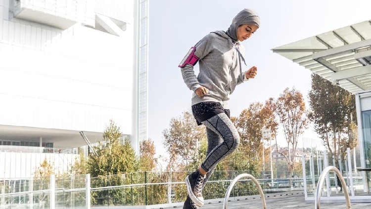 Athletic muslim woman is exercising on staircase
