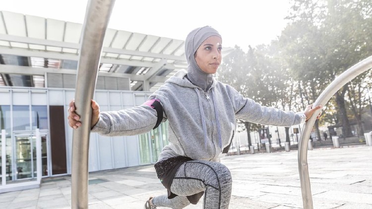Athletic muslim woman is exercising on staircase