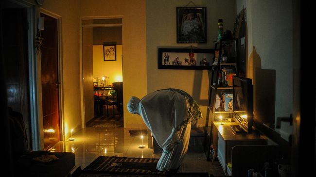 Umat Islam melaksanakan Shalat Tarawih saat permukimannya terdampak pemadaman listrik di Cinunuk, Kabupaten Bandung, Jawa Barat, Kamis (23/4/2020). Selama pandemi COVID-19, pemerintah menghimbau agar masyarakat untuk melaksanakan Shalat Tarawih di rumah guna mengantisipasi penyebaran COVID-19. ANTARA FOTO/Raisan Al Farisi/aww.