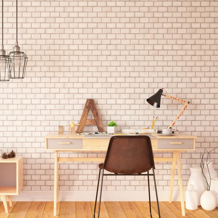 Berbeda dengan sebelumnya, dinding ruang kerja ini diberi aksen batu bata. Meja dan kursi kerja yang simpel mempertegas gaya minimalis ruang ini. (Foto: iStock)