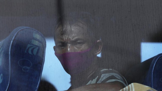 A bus passenger wears mask at a checkpoint during the imposition of large-scale restriction to curb the spread of the new coronavirus outbreak in toll road Cikarang, West Java, Indonesia, Friday, April 24, 2020. Indonesia is suspending passenger flights and rail service as it restricts people in the world's most populous Muslim nation from traveling to their hometowns during the Islamic holy month of Ramadan because of the coronavirus outbreak.(AP Photo/Achmad Ibrahim)