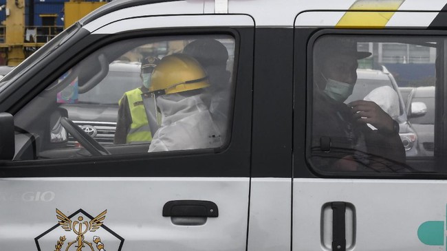 Warga Negara Indonesia (WNI), anak buah kapal Kapal Pesiar MV Arthania yang diduga positif COVID-19 (kanan) berada di dalam mobil ambulans di Pelabuhan JICT, Tanjung Priok, Jakarta, Jumat (24/4/2020). Sebanyak 56 WNI tersebut akan dibawa menuju RS Darurat COVID-19 Wisma Atlet Kemayoran untuk diobservasi. ANTARA FOTO/Muhammad Adimaja/wsj.